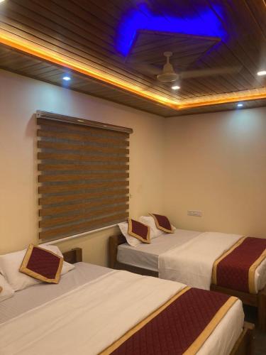 two beds in a room with a window at Road Trip Retreat in Belagula