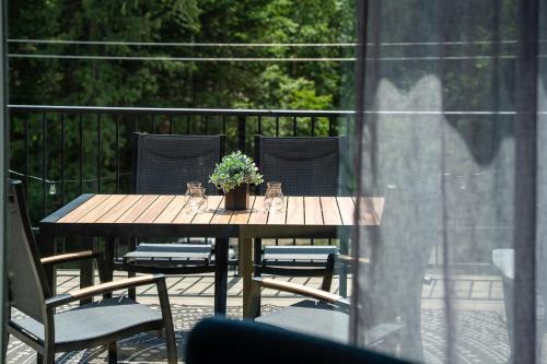a wooden table with a potted plant on a patio at The First Tracks Flat in Revelstoke