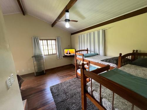 a room with three beds and a window at Casa nas Montanhas em Domingos Martins in Domingos Martins