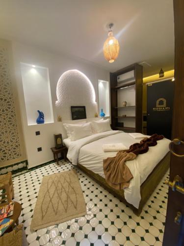 a bedroom with a large bed and a chandelier at RIAD KS & SPA in Marrakesh