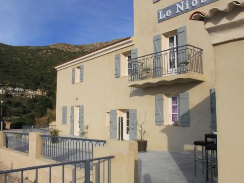 a building with a sign on the side of it at Hôtel Le Niobel in Belgodère