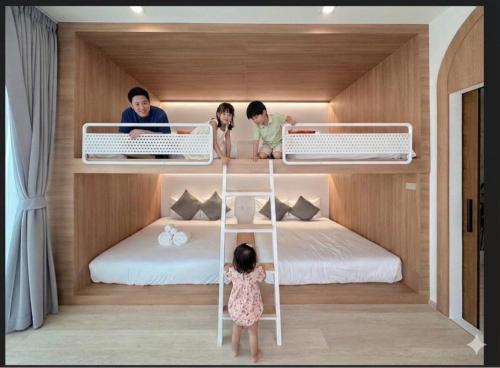 a group of children sitting on a bunk bed at The Pool Space - ICONIC Pool Villa in Ban Huai Yai