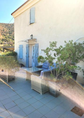 a house with a blue door and a patio at Hôtel Le Niobel in Belgodère