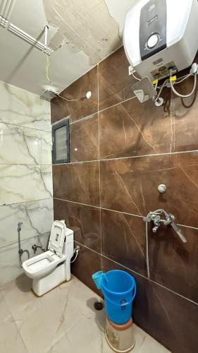 a bathroom with a toilet and a camera on the wall at Hotel Amrindra in Kharar