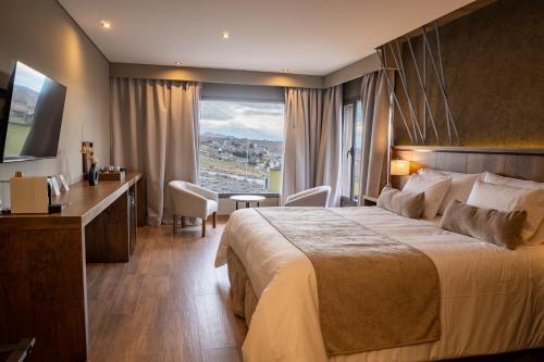 a hotel room with a large bed and a desk at Ayres de Calafate in El Calafate