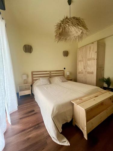 a bedroom with a large bed with a wooden floor at Pérola VerdeMar in Quarteira
