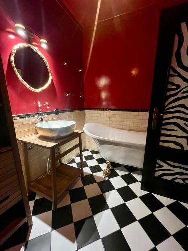 a bathroom with a tub and a sink and red walls at Pérola VerdeMar in Quarteira