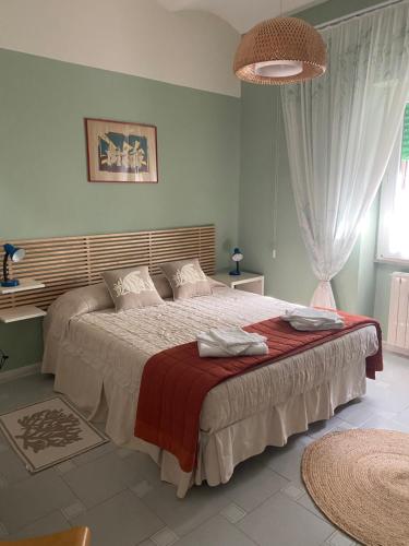 a bedroom with a large bed with a red blanket at Casa Diana in Tarquinia