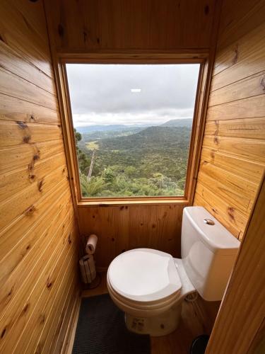 a small bathroom with a toilet and a window at Texas Hill Pousada e Camping in Urubici