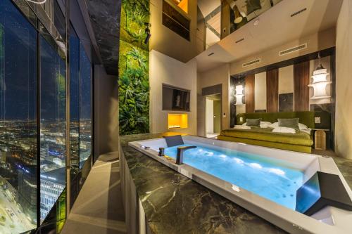 a bathroom with a large tub in the middle of a room at Sky Tower Apartamenty - In The Sky Apartments in Wrocław