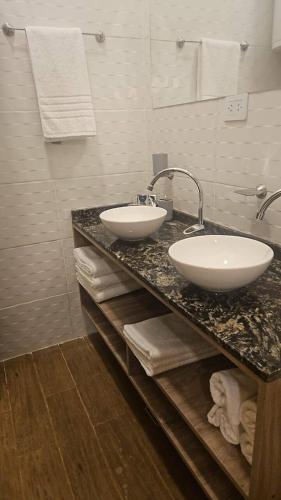a bathroom with two sinks on a counter with towels at Andes Xtreme Hotel Boutique in Tinogasta