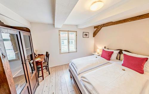 a bedroom with a large bed with red pillows at himmlischer Hof - Juwel von 1477 mit P, romantischer Innenhof, Kamin, Öko, Denkmal in Quedlinburg