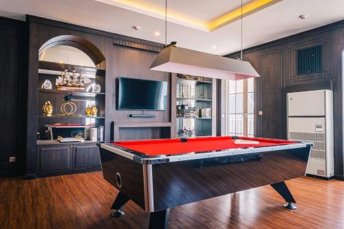 a red pool table in a room with a tv at Grand Florida Beachfront Resort Jomtien Pattaya in Na Jomtien