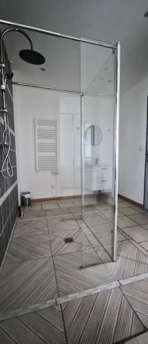 a glass shower in a room with a desk at Gîte Côte et Terre in Questrecques