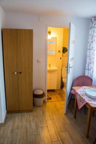 a small room with a table and a bathroom at Noclegi U Asi in Polańczyk