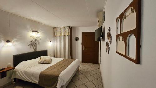 a hotel room with a bed and a television at Résidence Hôtelière La Farguaise 3min du péage in Fargues-de-Langon