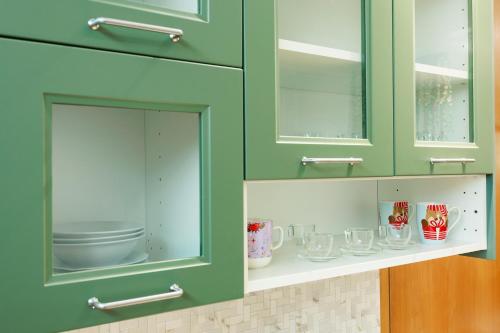 a green cabinet with glasses on a shelf at Bom Braga AL in Braga