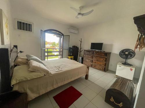 a bedroom with a bed and a tv and a window at Casa com 2 suítes com ar in Cabo Frio