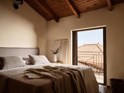 a bedroom with a bed and a large window at Rosa Sea Front Maisonette in Alikanas