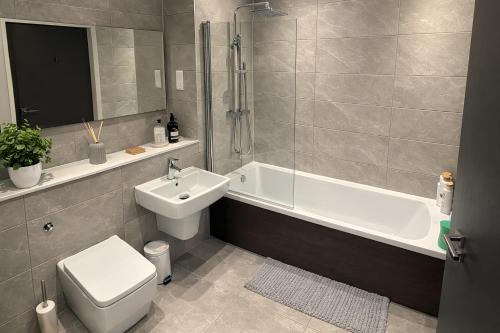 a bathroom with a sink and a toilet and a bath tub at Stunning Albert Dock Penthouse in Liverpool