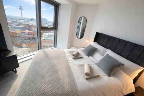a bedroom with a large bed with a large window at Stunning Albert Dock Penthouse in Liverpool