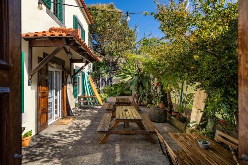 an alley with wooden picnic tables in a building at Jaca Hostel Porto da Cruz in Porto da Cruz