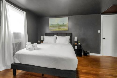 a bedroom with a large white bed and a window at Central location Parking in Cheektowaga