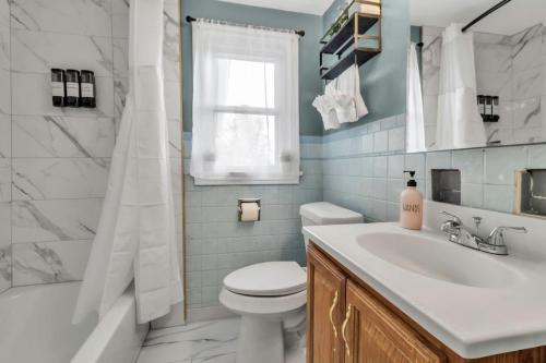 a bathroom with a sink and a toilet and a tub at Central location Parking in Cheektowaga