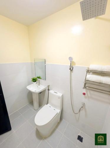 a bathroom with a toilet and a sink at Arron Grand Inn in Zamboanga