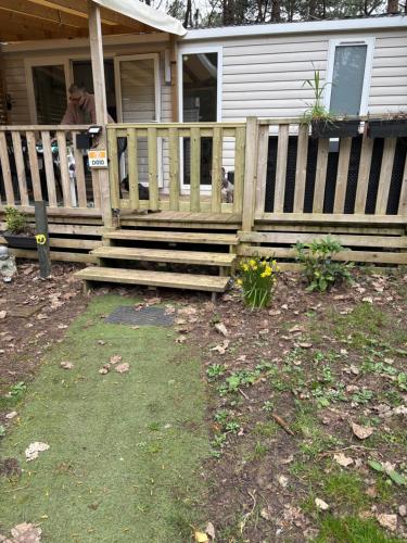 a wooden fence in front of a house at Au petit paradis in Camiers