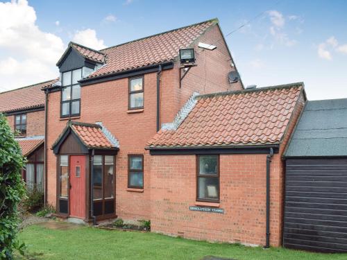 a red brick house with a black garage at Capstan Cottage in Whitby