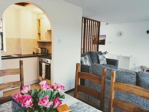 a living room with a couch and a kitchen at Capstan Cottage in Whitby