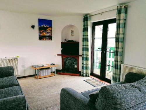 a living room with two couches and a fireplace at Capstan Cottage in Whitby