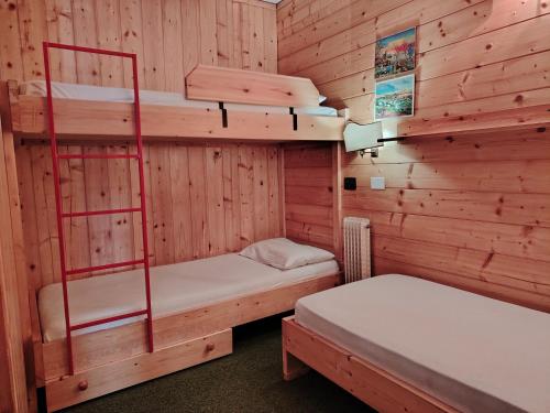 a room with two bunk beds in a cabin at APPARTAMENTI LATEMAR con PISCINA e SAUNA in Cavalese