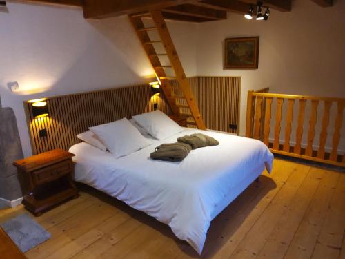 a bedroom with a large white bed and a staircase at Gite en chartreuse in Proveysieux