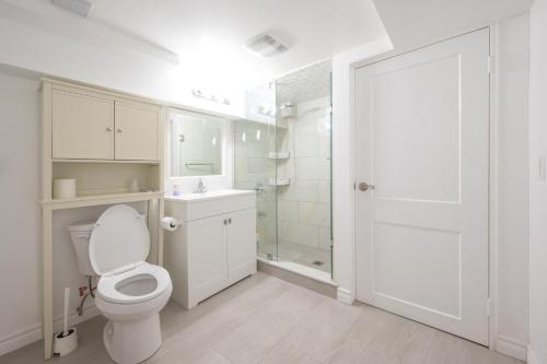 a white bathroom with a toilet and a shower at Comfy Private Basement- Scarborough in Toronto
