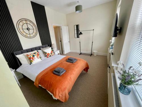 a bedroom with a bed with a clock on the wall at Spacious 2-Bedroom Eastbourne House Great Location in Eastbourne