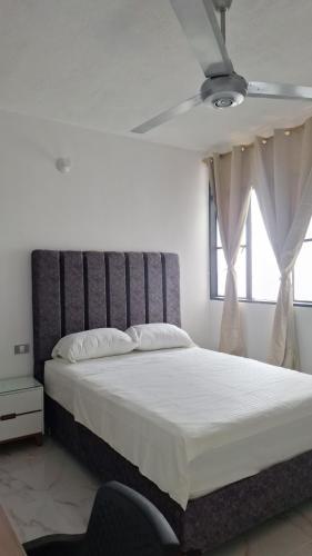 a bedroom with a large bed with a ceiling fan at Edificio Torre in Barrancabermeja