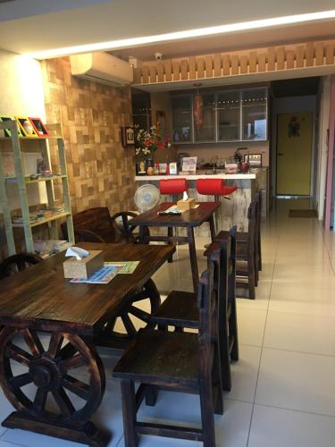 Un restaurante con mesas y sillas de madera y un mostrador. en Macaron B&B, en Luodong