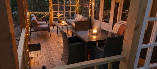 a screened in porch with a table and chairs at Chalet Bosrust met serre & privéparking Natuur nabij Maastricht in Lanaken