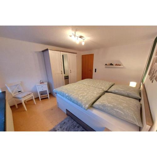 a bedroom with a bed and a chair in it at Ferienwohnung Eifelherzen in Demerath