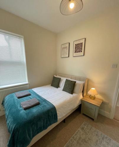 a bedroom with a bed with a blue blanket at Spacious 2-Bedroom Eastbourne House Great Location in Eastbourne