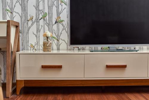 a tv sitting on top of a white dresser at Guangzhou Bokeshijia Hotel in Guangzhou
