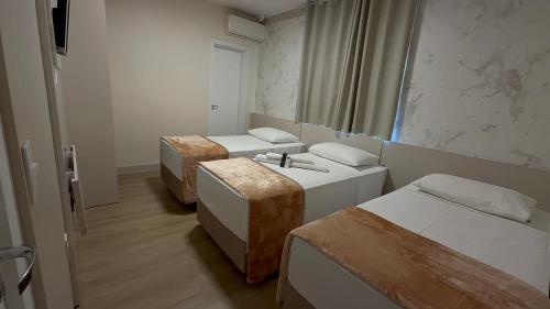 ein Zimmer mit zwei Betten und einem Waschbecken in der Unterkunft Hotel Maichel in Erval Velho