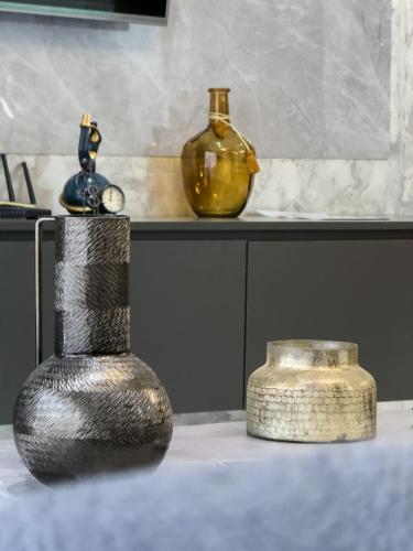 a black vase sitting on a table with other items at Luxury Double Bed Suite at THE HIDDEN DOMUS I Anomabo Suite in Accra