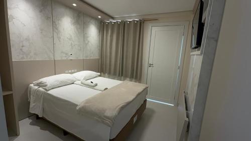 ein kleines Schlafzimmer mit einem Bett und einem Spiegel in der Unterkunft Hotel Maichel in Erval Velho