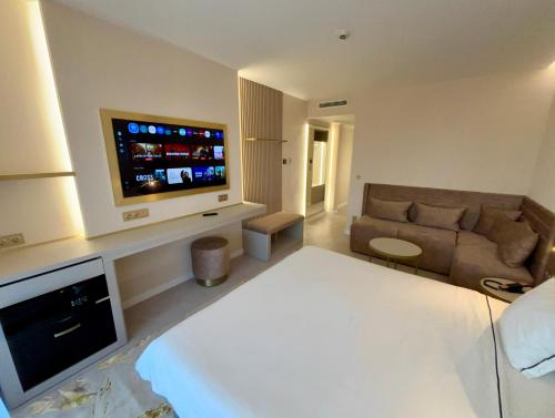 a living room with a couch and a flat screen tv at Belenus Thermalhotel in Zalakaros