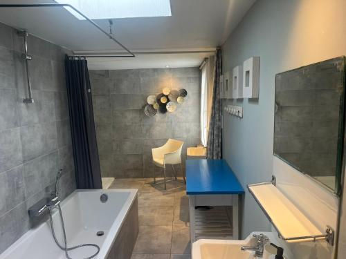 a bathroom with a tub and a sink and a bath tub at Gite La Cigogne in Couvin