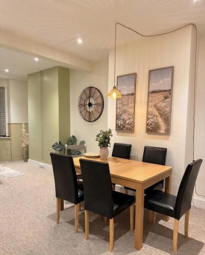 a dining room with a wooden table and black chairs at Spacious 2-Bedroom Eastbourne House Great Location in Eastbourne