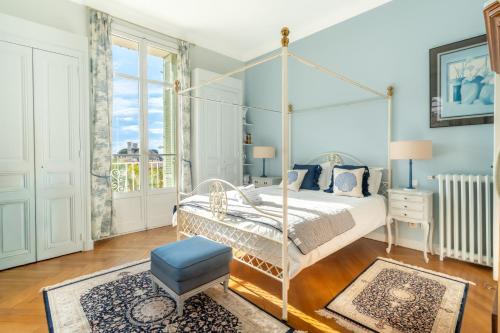a bedroom with a white canopy bed and a blue stool at Villa Blue Riviera & Le Joyau de la baie de Cannes in Cannes